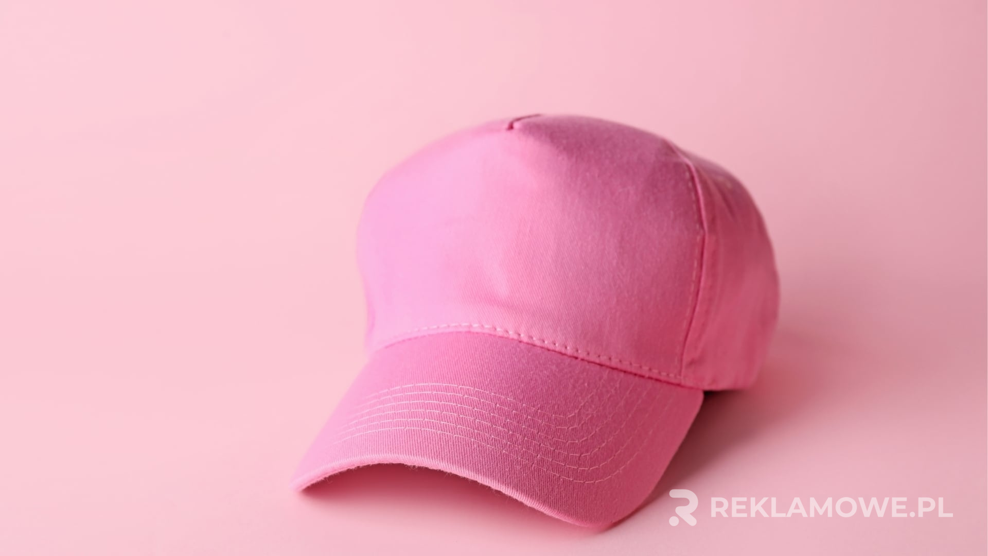 Czapka reklamowa na tle innych gadżetów promocyjnych
